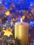 Lighted candle arrangement surrounded by Christmas decorations
