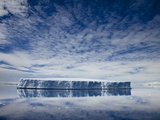 Tabular iceberg reflected in still water