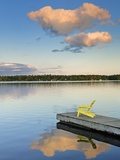 Clouds reflected in Silent Lake with Muskoka chair on dock