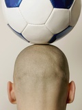 Man with soccer ball on head  rear view  close-up