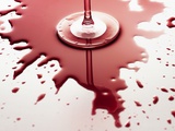 Red wine spilled around glass
