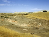 A Black Car Sits on a Hill Overlooking Desolate Badlands