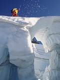 Climber crossing snow bridge on coleman glacier