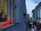 An Elderly Woman Has a Front-Window View of a Good Friday Procession