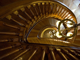 Looking Down a Spiral Staircase Past a Hanging Chandelier