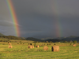 A Double Rainbow Appears over Hay Bales in Mountain Field