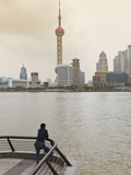A Man Looking at the Oriental Pearl Tower and Pudong Skyline across the Huangpu River from the Bund