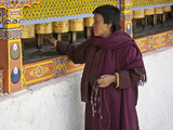 A Woman  Prayer Beads in Hand Spins Brass Prayer Wheels as She Mutters Invocation to Protective Dei