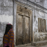 Zanzibar  Tanzania a Zanzibari Women in Traditional Khanga Robes  Passing an Old Wooden Door in St