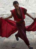 A Young Monk Holds His Red Robes and Runs across Wangdue Phodrang Dzong (Fortress) Courtyard  Massi