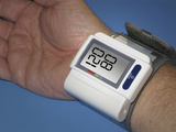 Hand of a Adult Male Wearing a Wrist Cuff for Measuring Blood Pressure