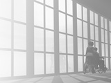 Person Pushing a Wheelchair Down a Hallway