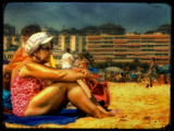 An Old Woman Wearing a Bathing Costume and White Hat Sitting on a Beach with Hotels