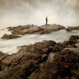 A Lone Man Standing on Large Rocks with the Seas Swirling around Them