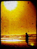 The Silhouette of an Adult Figure Walking on the Beach with a Setting Sun