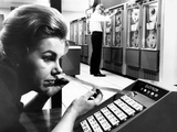 Woman Holds Tape with the Latest Stock Prices Printed by the Quotron II