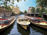 Refurbished Old Canal Cruise Boats Moored Along Amstel Canal in Amsterdam  the Netherlands