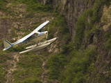 A Bush Pilot Flies His Float Plane Close to Mountain in Alaskan Canyon  USA