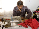 Young Male Nepali Factory Worker Sewing a Fleece at a Sewing Machine in a Factory  Kathmandu  Nepal