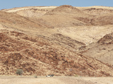 Red Rocky Landscape with Jeep in Distance  Purros Conservancy Wilderness  Kaokoland  Namibia