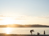 Silhouette of Mother Taking Pictures of Children at Sunset  Vashon Island  Washington State  USA
