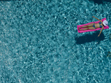 A Girl Floating on a Pink Raft in a Swimming Pool