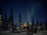 Aurora Borealis over a Home in a Snowy Landscape with Evergreen Trees