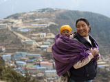 A Woman Carries Her Baby in a Blanket with Namche Visible Behind