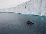 People in an Inflatable Boat Exploring an Ice Shelf