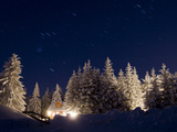 Stars in the Sky Above a House in a Snowy Forest