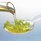 Oil Running onto Lettuce Leaf on Spoon