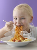 Blond Girl Eating Spaghetti with Tomato Sauce