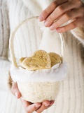 Hands Holding Almond Biscuits in Small Basket (For Christmas)