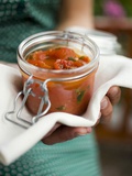 Hands Holding Preserving Jar of Tomato Sauce