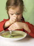 Girl Cutting a Broccoli Floret in Vegetable Soup
