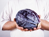 Man Holding a Red Cabbage in Both Hands