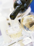 White Wine Pouring from Bottle into Glass; White Background