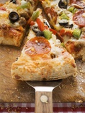 Piece of Pepperoni Pizza with Peppers and Olives on Server