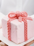 Hands Holding Cake with Marzipan Ribbon