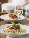 Spaghetti with Tomato Sauce and Glasses of White Wine on Table