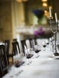 Table Laid in White with Glasses of Red Wine