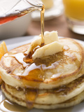 Pouring Maple Syrup over Pancakes with Dab of Butter